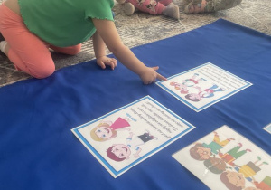 Dziewczynka kładzie na materiale ilustracje chłopca i dziewczynki