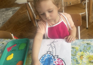 Dziewczynka palcem stępluje balon