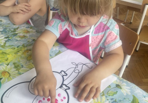 Dziewczynka różową farba stępluje balon
