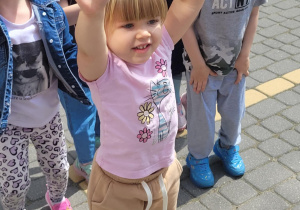 Diewczynka podnosi ręce do góry