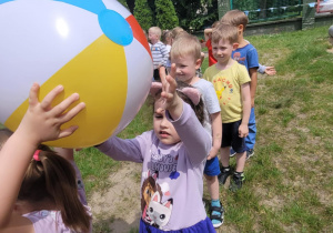 Dzieci podaja piłkę nad głową