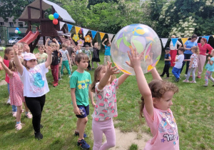Dziewczynki podają sobie balon