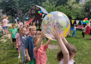 Dziewczynki podają sobie balon nad głową