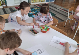 Dzieci kolorują ułożone z puzzli dzieci