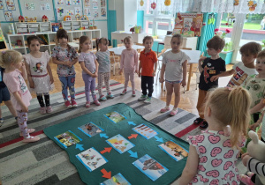 Dzieci stoją wokół ilustracji dzieci z różnych stron świata