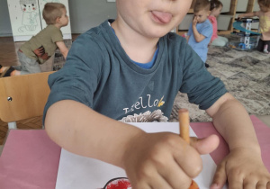 Chłopiec stempluje na czerwono kwiatka