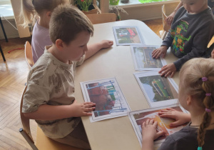 Dzieci oglądają ilustracje różnych autokarów