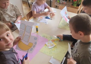 Dzieci wycinają nożyczkami przy stoliku
