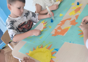 Dziewczynka siedzi z pomalowanym talerzykiem na kolor żółty