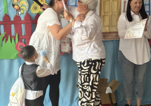 Dyrektor wręcza podzęikownaie mamie z grupy czwartej