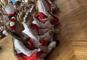 Dziewczynki siedzą w jednym rzędzie