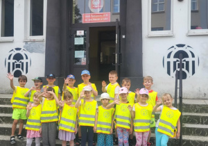Dzieci stoją przed budynkiem szkoły