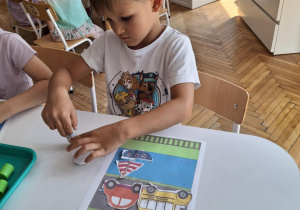 Chłopiec smaruje klejem lokomotywę