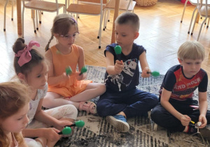 Dzieci z grzechotkami na dywanie