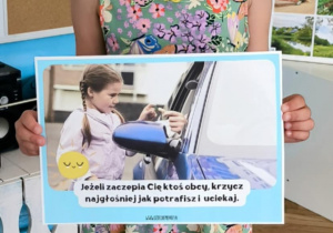 Dziewczynka pokazuje ilustrację tajemniczego samochodu