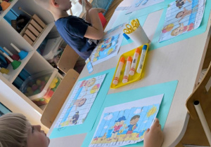Dzieci kleją paski puzzli