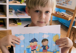 Chłopiec pokazuje ułożone puzzle