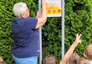 Pani dyrektor omawia z dziećmi regulamin placu zabaw