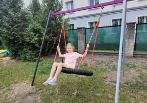 Dziewczynka buja się na bocianim gnieździe