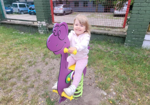 Dziewczynka na bujaku dinozaur