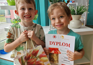 Dwoch chłopców z nagrodą i dyplomem za udział w akcji charytatywnej "Gorączka złota"