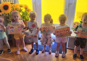 Dzieci stoją z planszami kodeksu przedszkolaka