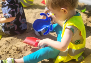Chlopiec bawi się w piaskownicy