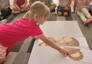 Dziewczynka dokłada jeden element puzzli