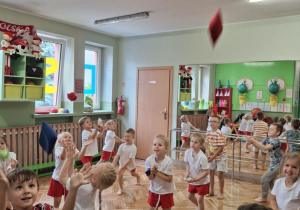 Dzieci podrzucają woreczek do góry