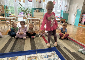 Dziewczynka pokazuje rysunek z sygnalizacją świetlną