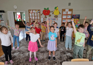 dzieci stoją na dywanie z podniesionymi rękami