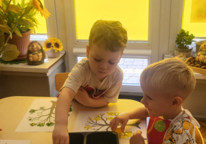 dzieci wykonują pracę plastyczną techniką stemplowania