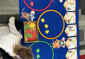 Dziewczynka wkłada zielone liście do koła