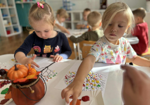 Dziewczynki stemplują palcem kontur drzewa