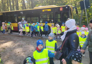 dzieci idą w parach przed autobusem