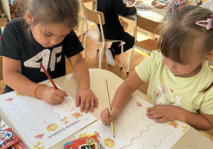 Dzieci kreślą znaki literopodobne