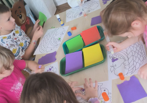 Dzieci drą kolorowy papier na drobne części