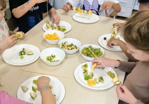 Dzieci mają na talerzach owoce