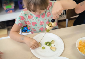 Dziewczynka nabiera owoce