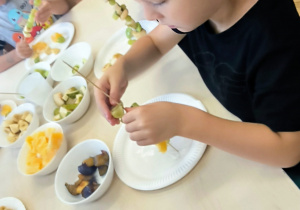 Chłopiec nadziewa winogrono