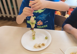 Chłopiec nadziewa winogrono na patyczek