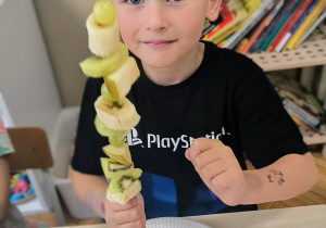 Chłopiec pokazuje owocowego szaszłyka