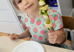 Dziewczynka z owocami na patyku