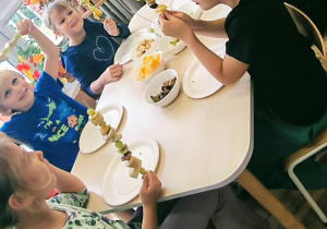 Dzieci poazkują swoje owocowe szaszłyki