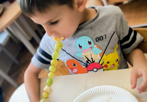 Chłopiec zjada owoce z patyczka