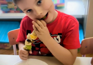 Chłopiec je owoce z patyczka