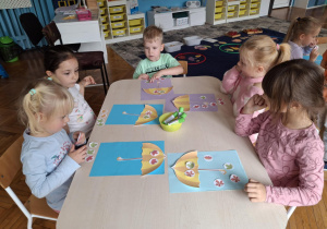 Dzieci układają liście na parasolu