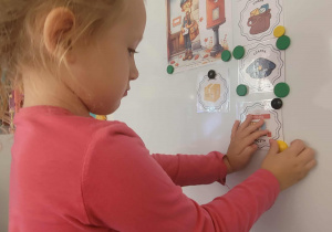Dziewczynka przyczepia rysunek poczty