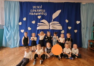 Dzieci z grupy pierwszej na tle dekoracji z okazji KEN