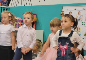 Dzieci stoją w półkolu i śpiewają piosenkę